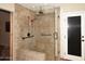 Modern tiled shower featuring glass surround, bench, and bronze fixtures at 17211 N 58Th St, Scottsdale, AZ 85254