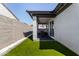 Covered back patio featuring stylish outdoor seating and an artificial grass lawn at 17320 W Daley Ln, Surprise, AZ 85387