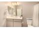Well-lit bathroom featuring a vanity with a sink, a mirror, and a toilet at 17320 W Daley Ln, Surprise, AZ 85387