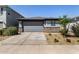 Exterior showcasing a home with a two-car garage, rock facade, and desert landscaping at 17320 W Daley Ln, Surprise, AZ 85387