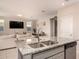 Kitchen island with stainless steel sink, complemented by a view of the living room at 17320 W Daley Ln, Surprise, AZ 85387