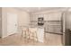 Modern kitchen featuring an island with counter seating and stainless steel appliances at 17320 W Daley Ln, Surprise, AZ 85387