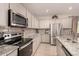 Well-lit kitchen with stainless steel appliances and granite countertops, ideal for cooking at 17320 W Daley Ln, Surprise, AZ 85387