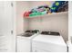 Convenient laundry room with appliances and shelf for storage at 17320 W Daley Ln, Surprise, AZ 85387