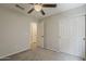 Bright bedroom featuring carpeting, a ceiling fan, and closet for ample storage at 1744 W Brookwood Ct, Phoenix, AZ 85045