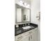 Stylish powder room featuring a white vanity with a black countertop, and an elegant mirror at 18550 N 94Th St, Scottsdale, AZ 85255