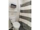 Bathroom displaying a toilet, striped shower curtain, towel rack, and an organized shelving unit at 18550 N 94Th St, Scottsdale, AZ 85255