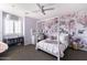 Light purple bedroom with a canopy bed, floral accent wall, and gray shelving unit at 18550 N 94Th St, Scottsdale, AZ 85255