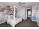 This bedroom includes a canopy bed, floral wallpaper, closet doors, and a ceiling fan at 18550 N 94Th St, Scottsdale, AZ 85255