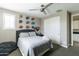 A well-lit bedroom with a sports-themed wall display, white closet doors, and modern ceiling fan at 18550 N 94Th St, Scottsdale, AZ 85255