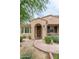 Welcoming front entrance with a decorative wreath, desert landscaping, and a charming covered porch at 18550 N 94Th St, Scottsdale, AZ 85255