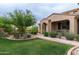 Inviting single-Gathering home featuring desert landscaping, lush green lawn, and covered front porch at 18550 N 94Th St, Scottsdale, AZ 85255