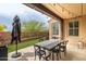 Beautiful covered patio with outdoor dining table, turf and desert landscaping at 18550 N 94Th St, Scottsdale, AZ 85255