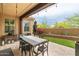 Beautiful covered patio with dining table, desert landscaping, and manicured turf at 18550 N 94Th St, Scottsdale, AZ 85255