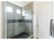 Modern bathroom shower featuring glass door, bench seating, and stylish gray and white tile design at 18550 N 94Th St, Scottsdale, AZ 85255