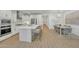 Spacious kitchen with stainless appliances, island seating, and open layout to the dining area with modern chandelier at 1876 S Huish Dr, Gilbert, AZ 85295