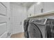 Modern laundry room with new washer and dryer and overhead cabinets at 1876 S Huish Dr, Gilbert, AZ 85295