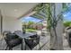 Inviting outdoor patio with modern table, lush plants, and charming yard at 1876 S Huish Dr, Gilbert, AZ 85295