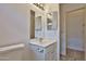 Bright bathroom featuring double mirrors, a neutral color scheme, and a well-lit vanity area at 19002 N Toledo Ave, Maricopa, AZ 85138