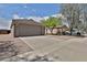 Single-story house with a two-car garage, desert landscaping, and a spacious driveway at 19002 N Toledo Ave, Maricopa, AZ 85138