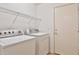 Practical laundry room with washer, dryer, wire shelving, and convenient access to other areas at 19002 N Toledo Ave, Maricopa, AZ 85138