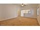 Neutral living room with neutral carpeting, ceiling fan, and lots of natural light at 19002 N Toledo Ave, Maricopa, AZ 85138