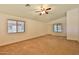 Spacious living room featuring large windows and neutral carpeting at 19002 N Toledo Ave, Maricopa, AZ 85138