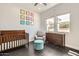 This cozy Bedroom features a wood crib, soft gray chair, and colorful animal artwork at 19935 E Via Del Palo --, Queen Creek, AZ 85142