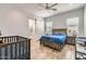 Spacious bedroom with a king bed, a sliding barn door leading to the en suite bathroom, and a crib at 19935 E Via Del Palo --, Queen Creek, AZ 85142