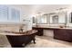 Bathroom showcasing a freestanding copper tub, dual vanities, and travertine tile at 20410 N 51St Dr, Glendale, AZ 85308