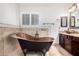 Bathroom featuring a freestanding copper tub and dual sink granite vanity at 20410 N 51St Dr, Glendale, AZ 85308