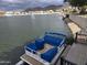 Exterior shot of a blue pontoon boat docked on calm water, with a view of the neighborhood beyond at 20410 N 51St Dr, Glendale, AZ 85308