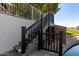 Exterior shot of a wooden dock with black railing stairs, with a view of landscaping and backyard area at 20410 N 51St Dr, Glendale, AZ 85308