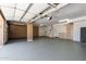 Spacious garage with painted floor, storage cabinets, and an automatic garage door at 20410 N 51St Dr, Glendale, AZ 85308