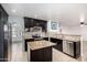 Well-equipped kitchen featuring dark cabinets, granite counters, stainless appliances, and a convenient center island at 20410 N 51St Dr, Glendale, AZ 85308