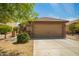 Tan two-car garage with stone accents and a well-maintained desert landscape at 22191 W Tonto St, Buckeye, AZ 85326