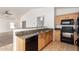 Open kitchen features granite countertops, stainless sink, and modern black appliances at 2433 W Hayden Peak Dr, San Tan Valley, AZ 85144