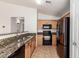 Bright kitchen features neutral cabinetry, granite counters and black appliances at 2433 W Hayden Peak Dr, San Tan Valley, AZ 85144