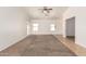 Bright and spacious living room features large windows, neutral carpet, and light-filled atmosphere at 2433 W Hayden Peak Dr, San Tan Valley, AZ 85144