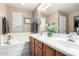 Bathroom vanity with double sinks, neutral walls and a bathtub to the left at 2533 W Cordia Ln, Phoenix, AZ 85085