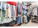 Walk-in closet with clothes on hangers, shelves with shoes and luggage on the floor at 2533 W Cordia Ln, Phoenix, AZ 85085