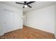 Bedroom featuring hardwood floors, ceiling fan, closet, and ensuite bath at 25825 N 65Th Ave, Phoenix, AZ 85083