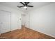 Bedroom featuring hardwood floors, ceiling fan, closet, and ensuite bath at 25825 N 65Th Ave, Phoenix, AZ 85083