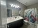 Bathroom with double sink vanity, a floral shower curtain, and a toilet at 30395 W Mitchell Ave, Buckeye, AZ 85396