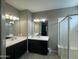 Bright bathroom featuring dual sinks, a large mirror, and a glass-enclosed shower at 30395 W Mitchell Ave, Buckeye, AZ 85396