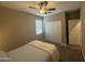 Well-lit bedroom with closet, ceiling fan, and a large window for natural light at 30395 W Mitchell Ave, Buckeye, AZ 85396
