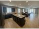 Modern open-concept kitchen featuring dark cabinets and a granite island at 30395 W Mitchell Ave, Buckeye, AZ 85396