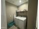 Laundry room featuring a washer, dryer, shelving, and an ironing board at 30395 W Mitchell Ave, Buckeye, AZ 85396