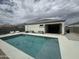 Backyard with a sparkling pool, patio area, and neatly maintained desert landscaping at 30395 W Mitchell Ave, Buckeye, AZ 85396