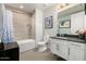 Well-lit bathroom featuring a shower-tub combo, gray tiling, and a modern vanity with black countertop at 3131 N Central Ave # 6010, Phoenix, AZ 85012